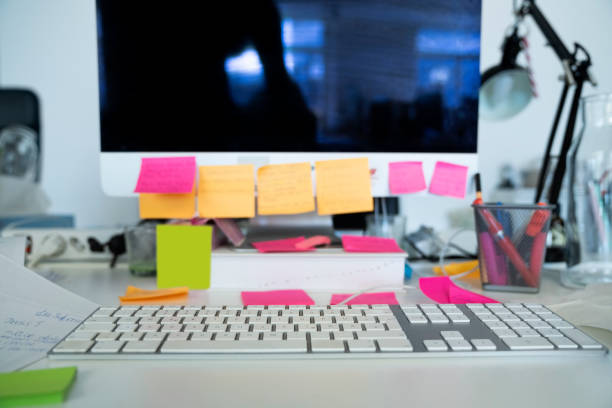 Post-it notes and binders around a scheduler's monitor